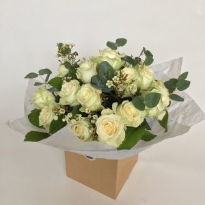 a bouquet full of white roses mixed with green eucalyptus and small white flowers